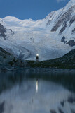 Fototapeta Morze - Zdjęcie turysty który maszeruje po zmroku na tle lodowca