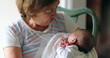 Grand-mother holdingnewborn baby infant candid