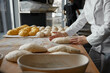 Baker hands preparing formed bread dough for proofing