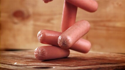 Poster - Sausages fall on a wooden table. Filmed on a high-speed camera at 1000 fps. High quality FullHD footage