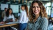 © buraratn - Smiling confident business leader looking at camera and standing in an office at team meeting. Portrait of confident businesswoman with colleagues in boardroom. Using digital tablet during a meeting.