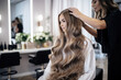 © Andrii Zastrozhnov - A professional hairstylist works on a young woman's long, wavy hair in a beauty salon.