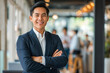 © MVProductions - Portrait of a handsome smiling Asian businessman boss in a suit standing in a modern business company office