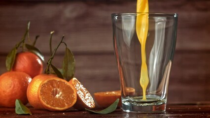 Canvas Print - Fresh tangerine juice is poured into a glass. Filmed on a high-speed camera at 1000 fps. High quality FullHD footage