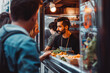 © VisualProduction - Owner looking at customers standing on street through food truck window