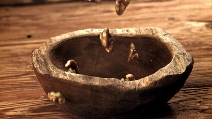 Wall Mural - Walnuts fall into a wooden bowl. Filmed on a high-speed camera at 1000 fps. High quality FullHD footage