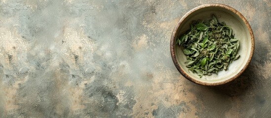 Wall Mural - Top view of a small ceramic bowl on textured paper with copy space, containing dried basil leaves.