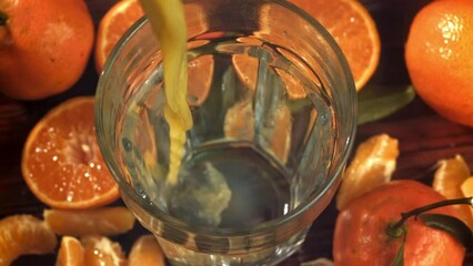 Canvas Print - Fresh tangerine juice is poured into a glass. Filmed on a high-speed camera at 1000 fps. High quality FullHD footage