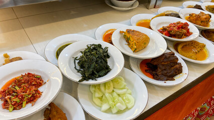 A line plate of various padang cuisine. One of the most popular meals in Indonesia, a mix of rice and side dishes originally from Padang, Indonesia.