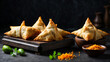 A vivid picture of the contrast between the crispy, flaky texture of the chicken samosas and the smooth, dark surface of the black wooden table