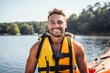 © Nerea - Handsome young man in life jacket is smiling while standing on the river bank