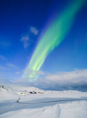 Canvas Print - Aurora Borealis in Iceland. Northern Lights over the road. A winter night landscape with bright lights in the sky. Landscape in the north in winter time. A popular place to travel.