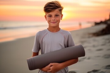 Sticker - Portrait of a boy holding yoga mat on the beach at sunset