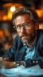 © TheGoldTiger - Bearded man with glasses, wearing a watch, sits thoughtfully in a warmly lit, cozy indoor setting., generative ai