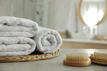 Poster - Wicker tray with clean towels on table in bathroom