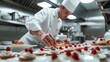 © Oulaphone - Pastry chef is completing a dessert in a hotel or restaurant kitchen.