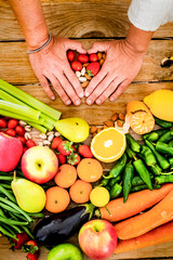 Wall Mural - Fresh and seasonal vegatables and fruit on a woodem table with people woman hands doing love hearth with it - healthy eat lifestyle concept for vegetarian or diet weight loss activity