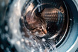 Scared cat inside washing machine drum with water flow and splashes.