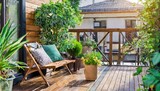 Fototapeta  - Beautiful of modern terrace with wood deck flooring, green potted flowers plants and outdoors furniture. Cozy relaxing area at home back yard. Sunny stylish balcony terrace in the city