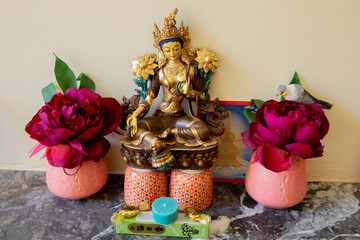 Green Tara statue with offerings in a buddhist temple in western France