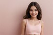 © PNG&Background Image - Attractive girl wearing a cropped tank top standing against a pink background with copy space.