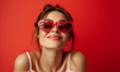 Leinwandbild Motiv Studio portrait of a cool young woman posing wearing heart shaped love sunglasses