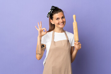 Cooker Slovak woman isolated on purple background showing ok sign with fingers