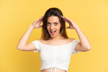 Young caucasian woman isolated on yellow background with surprise expression