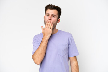 Wall Mural - Young caucasian man isolated on white background yawning and covering wide open mouth with hand