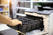 © Jintana - Technician open cover printer fix repair problem and replace drum and ink cartridges and for print scanning fax or copy document or photocopier or photocopy in office workplace service support concept