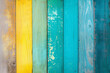 Colorful wooden background with vertical wooden slat of different bright colors and copy space. Multicolored boards with a rainbow of colors form a vibrant modern fence with wooden texture