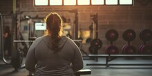 An Overweight Woman Stands With Her Back In The Gym Preparing To Play Sports, The Concept Of An Active Life, Taking Care Of The Body And Building A Relationship With Weight