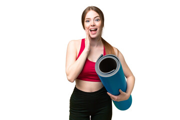 Sticker - Young sport woman going to yoga classes while holding a mat over isolated chroma key background with surprise and shocked facial expression