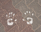Fototapeta  - Handprints on stone paving stones with white paint