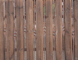 Fototapeta Na drzwi - Fragment of a fence made of wooden boards and brown iron rods.