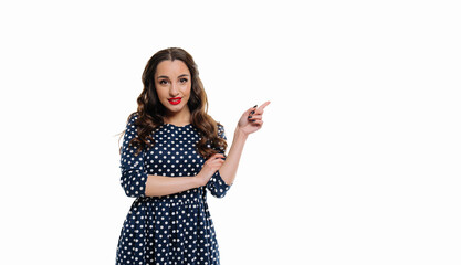 Wall Mural - Portrait of happy young woman pointing finger away at copy space isolated over white background