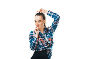 Wall Mural - Young woman in plaid shirt and black pants on white background in the studio straightens her hair with her hand.