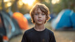 Young Boy Standing in Front of Group of Tents