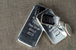 Silver bullion. Cast and minted bars and coins against the background of the texture of coarse cloth.