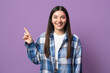 © Andrei - Multiethnic woman with attractive smile pointing with index finger up looking in camera against purple background
