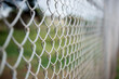 Fence with metal grid in perspective. Metal chain-link fence as the background, street photo, close-up,
