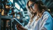 © Polpimol - Woman factory worker wearing glasses and white robe at polymer plastic manufacturing, using tablet for quality control and logistic purposes, checking machines and mechanisms
