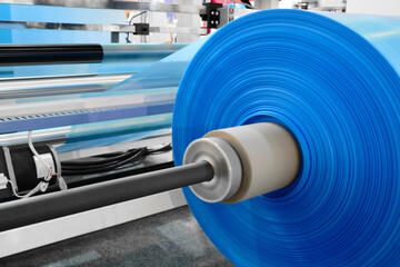 Poster - Automatic polyethylene plastic bag production machine with lighting effect. Close-up of the roller of the plastic bag production machine in the light blue scene. product packaging concept