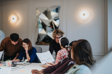 Wall Mural - Diverse team engaged in project discussion at modern office space.