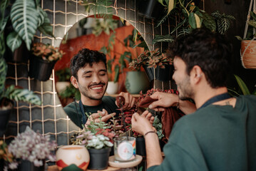 Young man smiles in plant store..concept: small plant and nursery business.