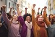 Multicultural group of women raising fists for International Womens Day. March 8 for feminism, independence, freedom, empowerment, and activism for women rights