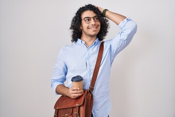 Wall Mural - Hispanic man with curly hair drinking a cup of take away coffee smiling confident touching hair with hand up gesture, posing attractive and fashionable