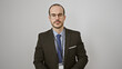 © Krakenimages.com - Confident hispanic man with a beard, bald, wearing glasses, suit, tie, and lanyard on a white background
