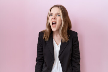 Young caucasian business woman wearing black jacket angry and mad screaming frustrated and furious, shouting with anger. rage and aggressive concept.