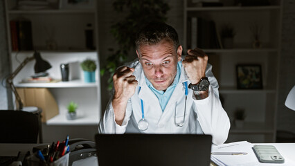 Poster - Stressed doctor in clinic office working late with computer and paperwork